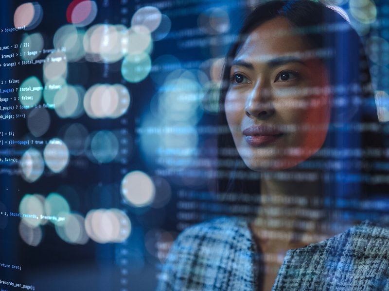 Portrait of Asian Female Startup Digital Entrepreneur Working on Computer, Line of Code Projected on Her Face and Reflecting. Software Developer Working on Innovative e-Commerce App using AI, Big Data